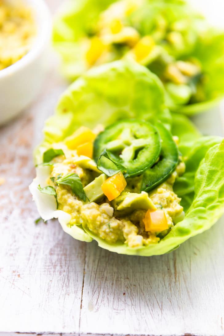 close up image of a Mexican avocado egg salad lettuce wrap topped with jalapenos
