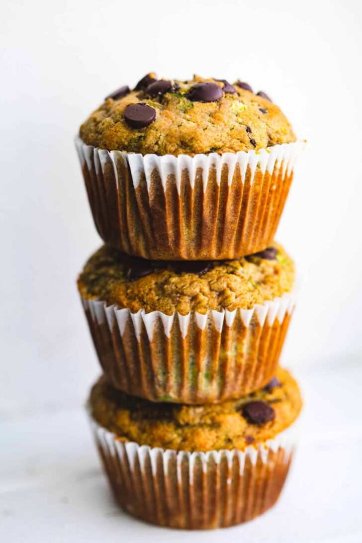 a stack of three chocolate chip gluten free zucchini muffins on top of each other