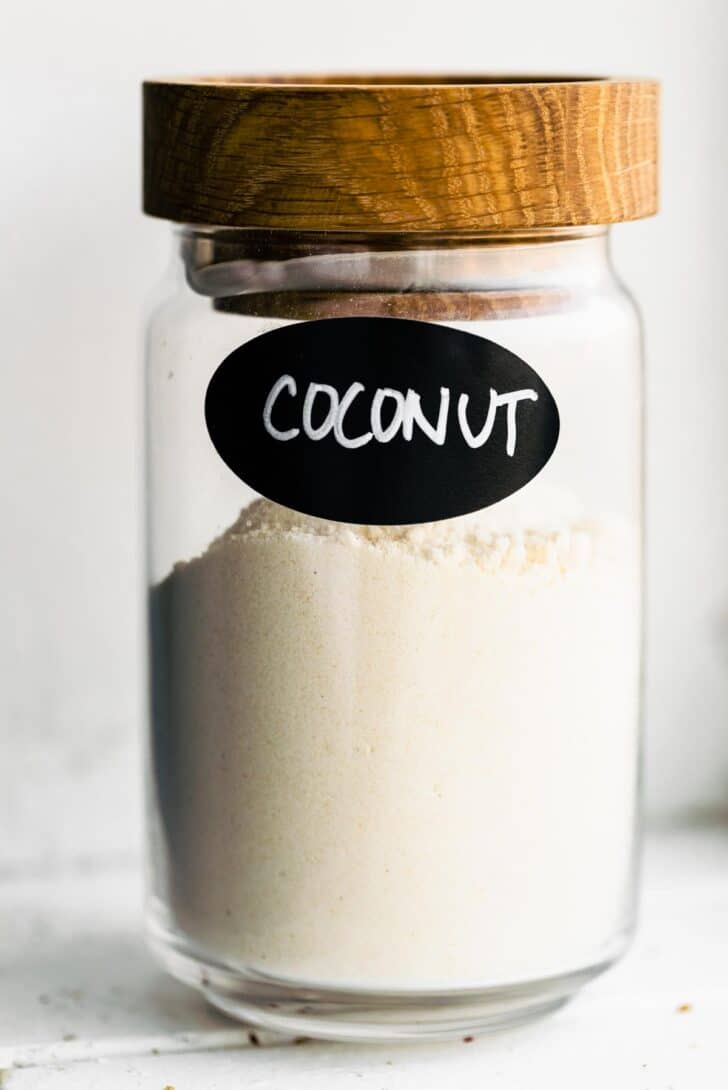 a glass jar of flour labeled coconut