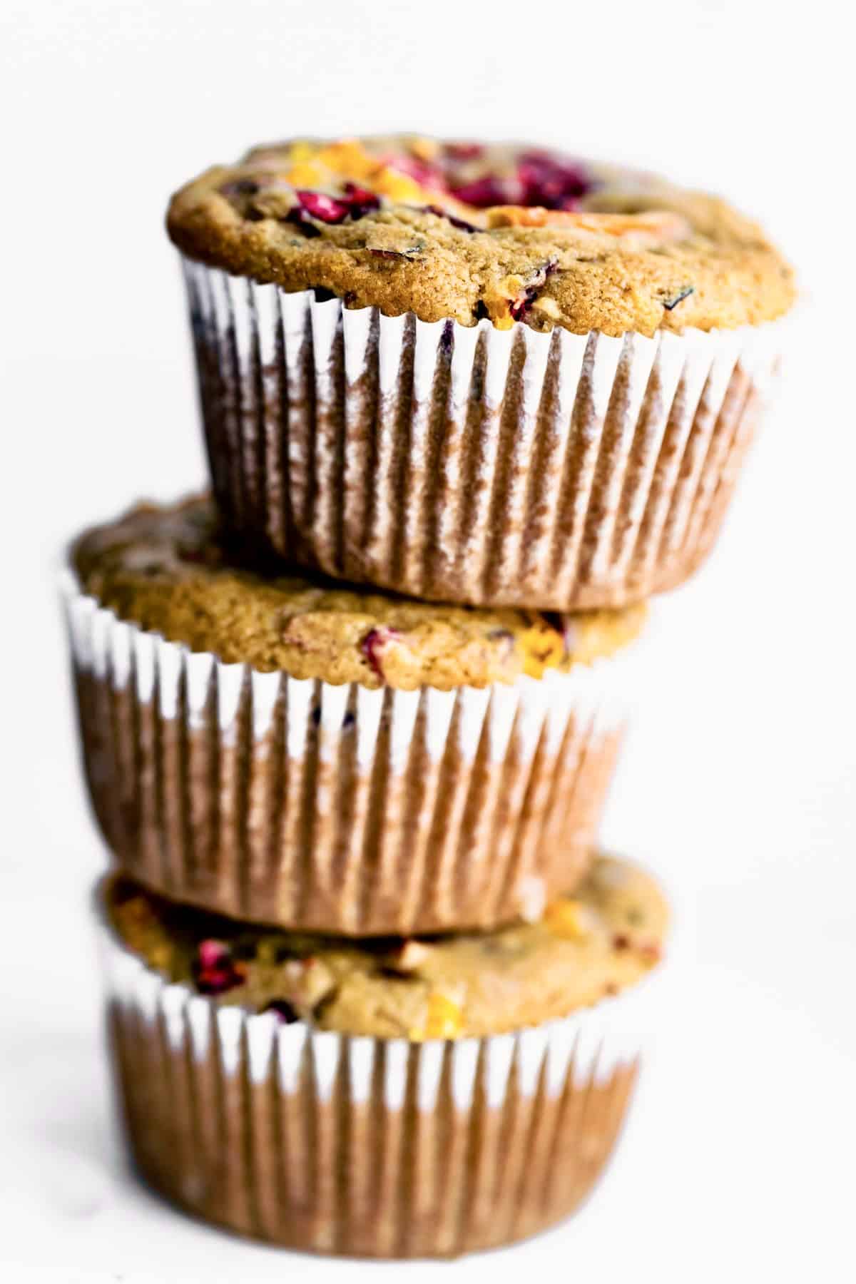 3 gluten free cranberry orange muffins stacked on top of each other
