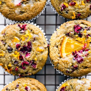 close up image of gluten free cranberry orange muffins on a cooling rack