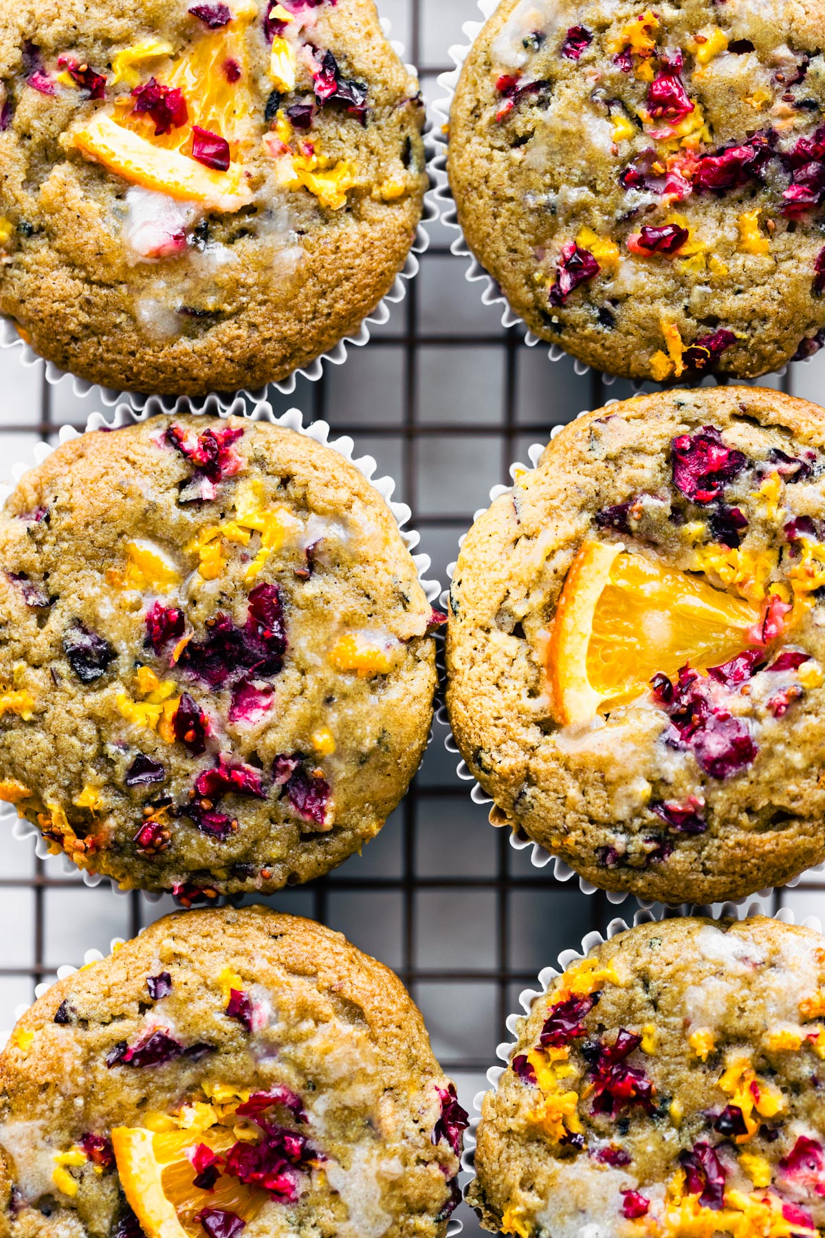 close up image of gluten free cranberry orange muffins on a cooling rack
