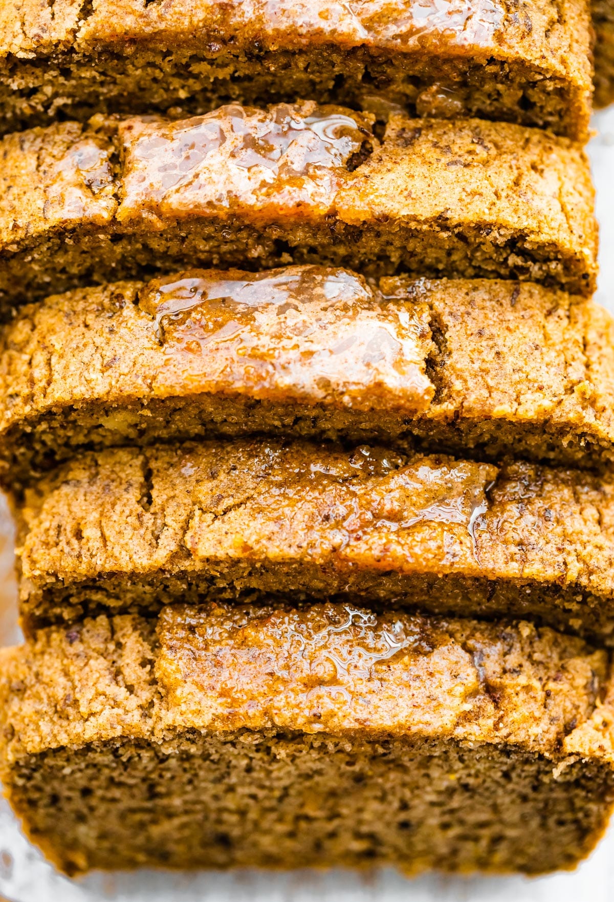 close up image of the top of sliced cinnamon almond flour bread pieces brushed with cinnamon butter