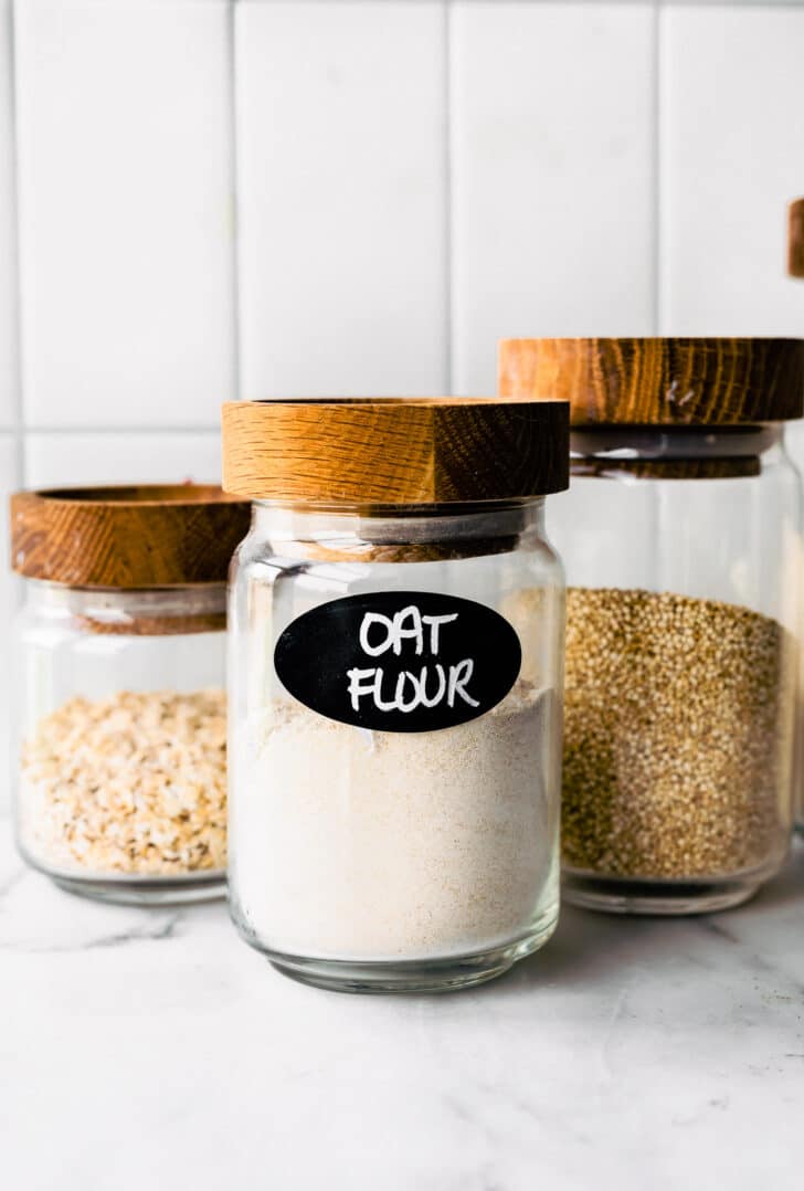 three glass jars with the front jar labeled oat flour