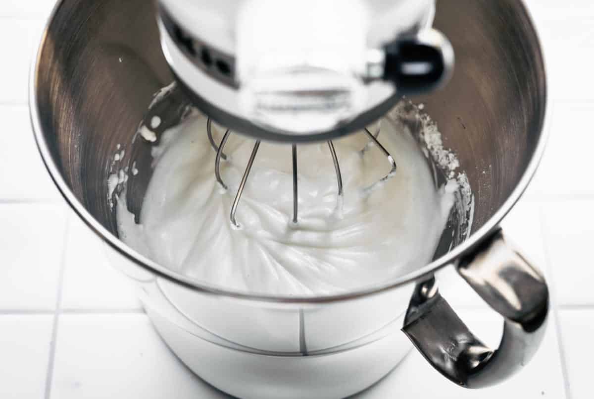 a stand mixer full of aquafaba whipped cream