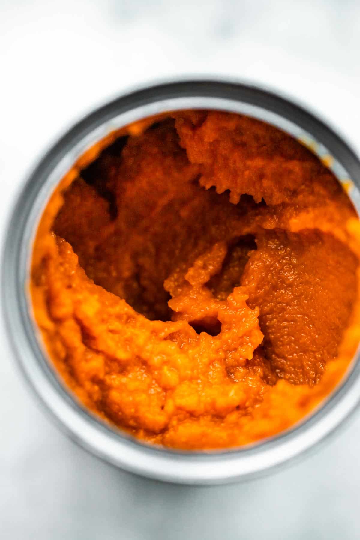overhead image of an open jar of pumpkin