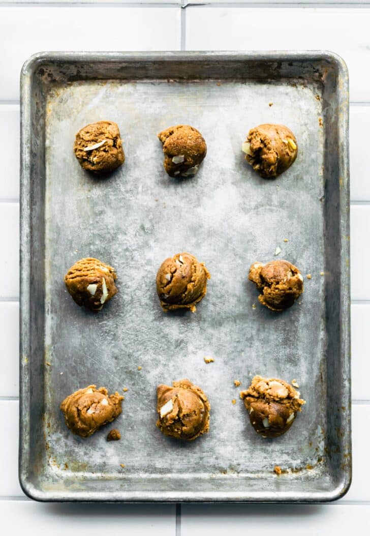 overhead shot of almond butter cookie dough on cookie sheet with almonds.