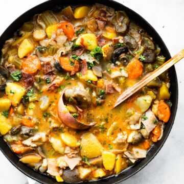 overhead shot of vegetable soup in pot with laddle in the middle