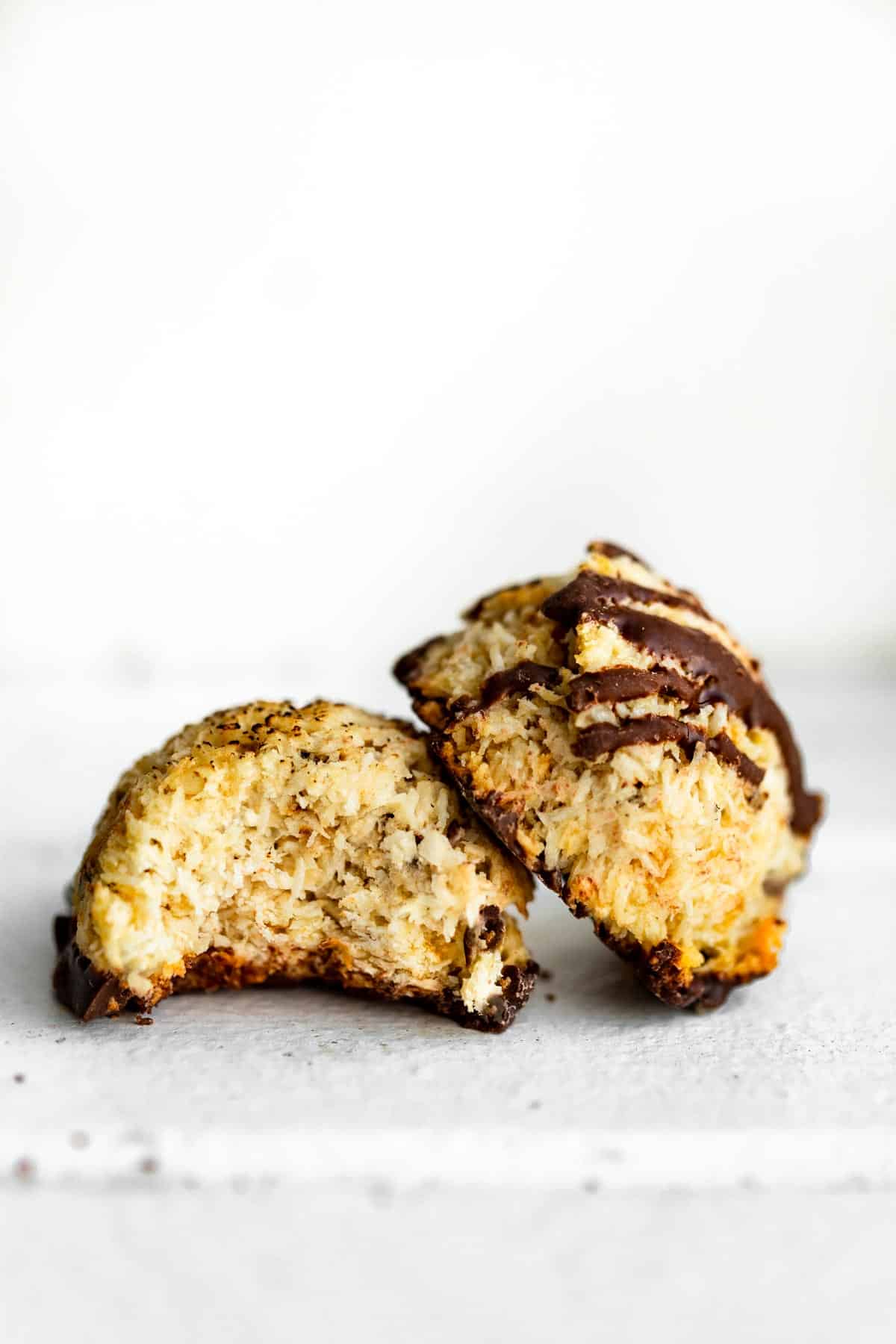 two vegan mocha coconut macaroons one with a bite taken out of it