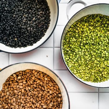 Overhead shot of Black Beans, Green Lentils, and Pinto Beans all in separate pots on counter top.
