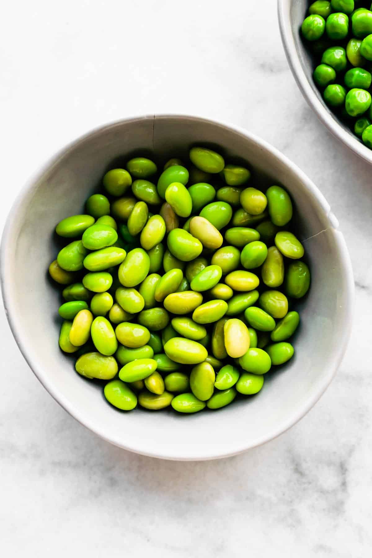 Overhead shot of green soybeans in a bowl on a counter top.