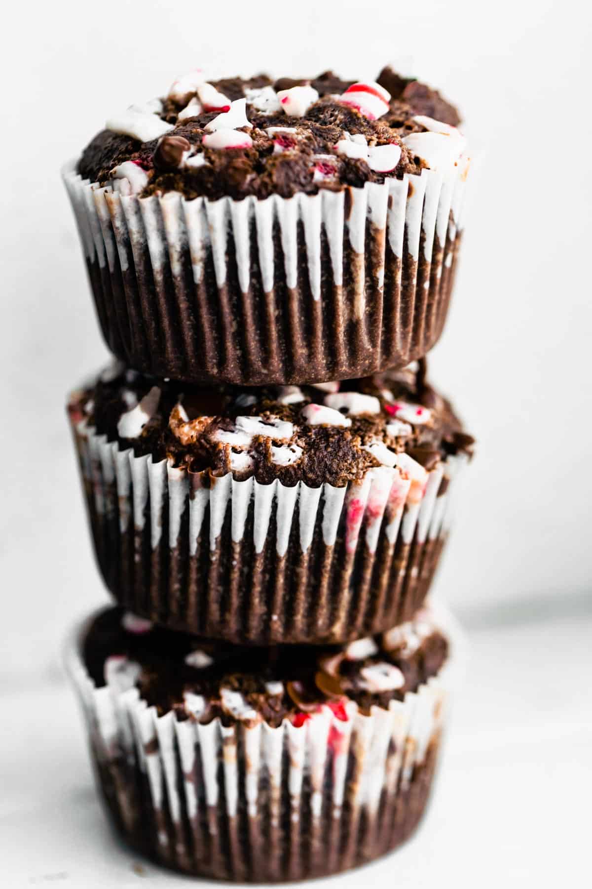 A stack of three gluten free Peppermint Chocolate Muffins on a white countertop.