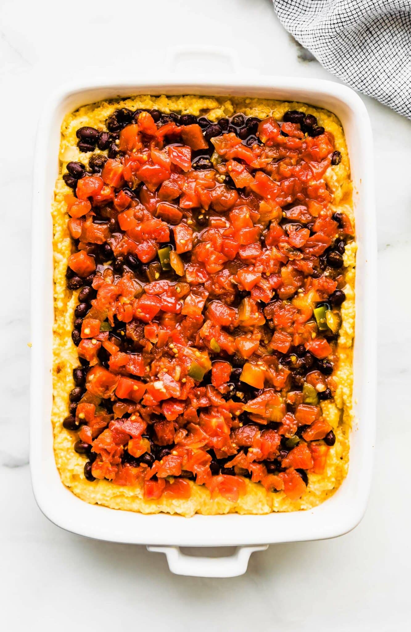 polenta, black beans, and tomatoes in a casserole dish