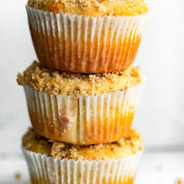 Three coffee cake muffins stacked on top of each other.