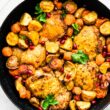 Overhead shot of Persian-Spiced Chicken and Potatoes in a pan garnished with pomegranates