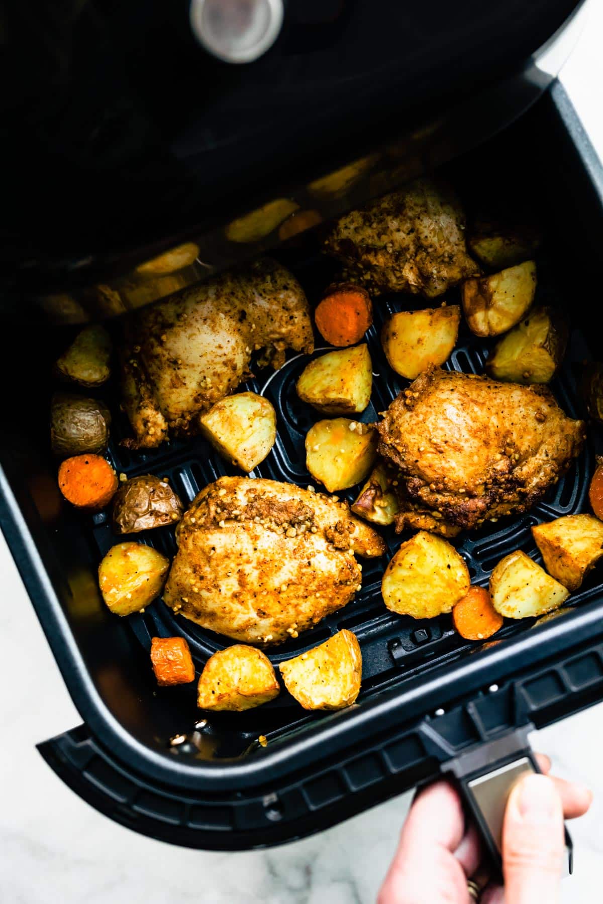 Overhead shot of an open air fryer with cooked Persian-Spiced Chicken and Potatoes.