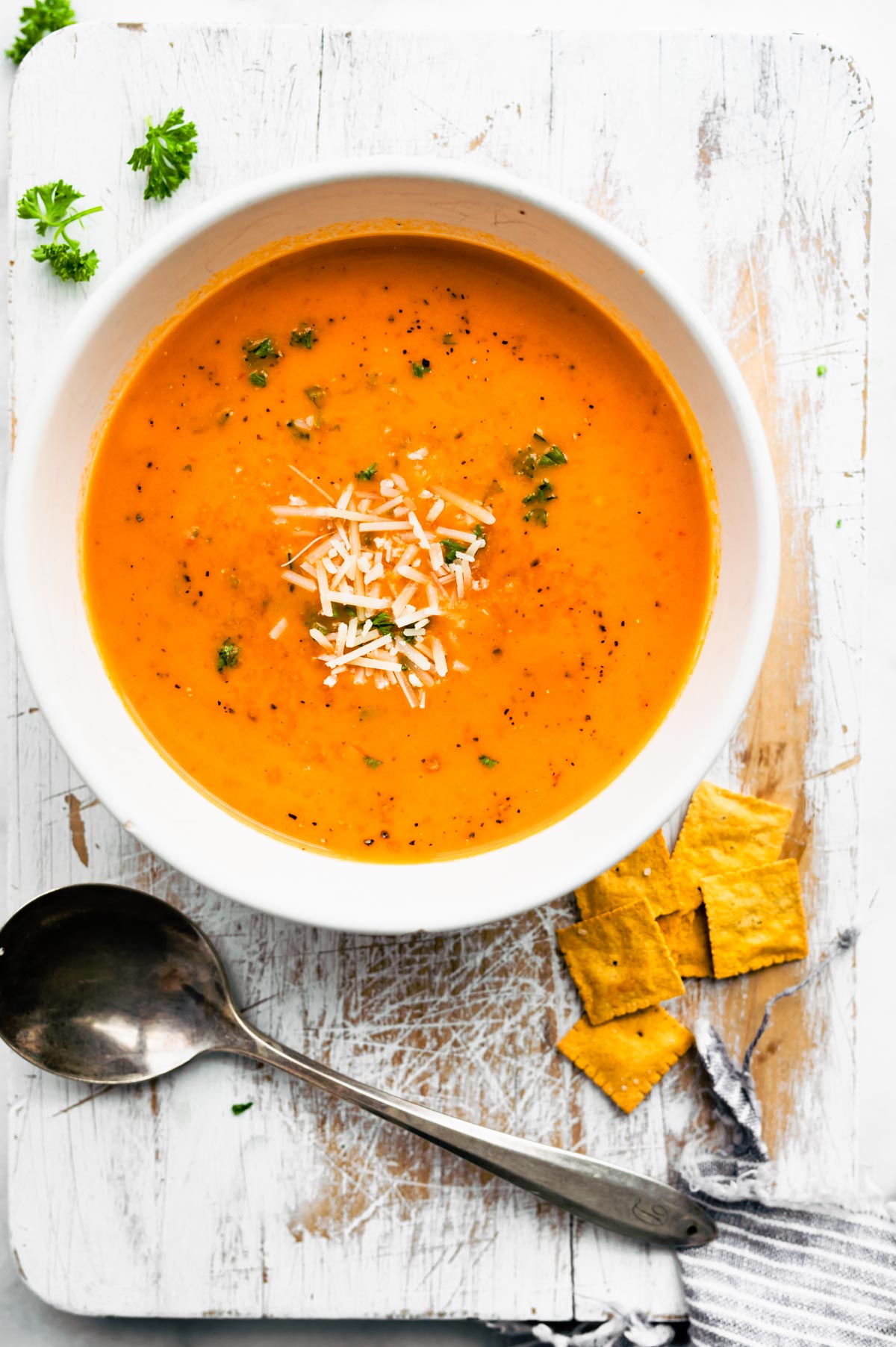 Roasted Red Pepper Soup topped with cheese in a bowl.