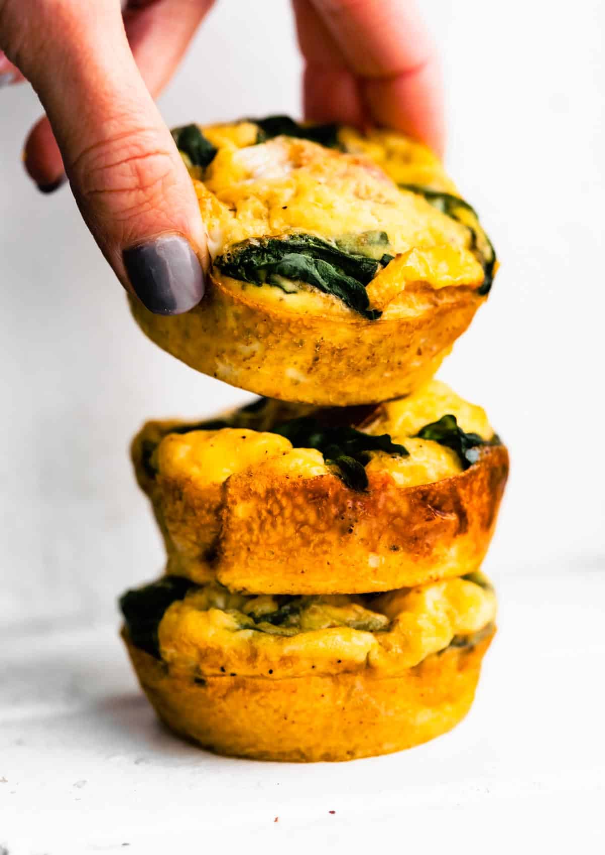Three Fritatta Muffins being stacked on one another.