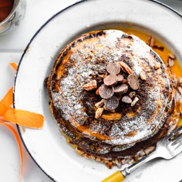 overhead image of a stack of gluten-free carrot cake pancakes on a plate with a fork
