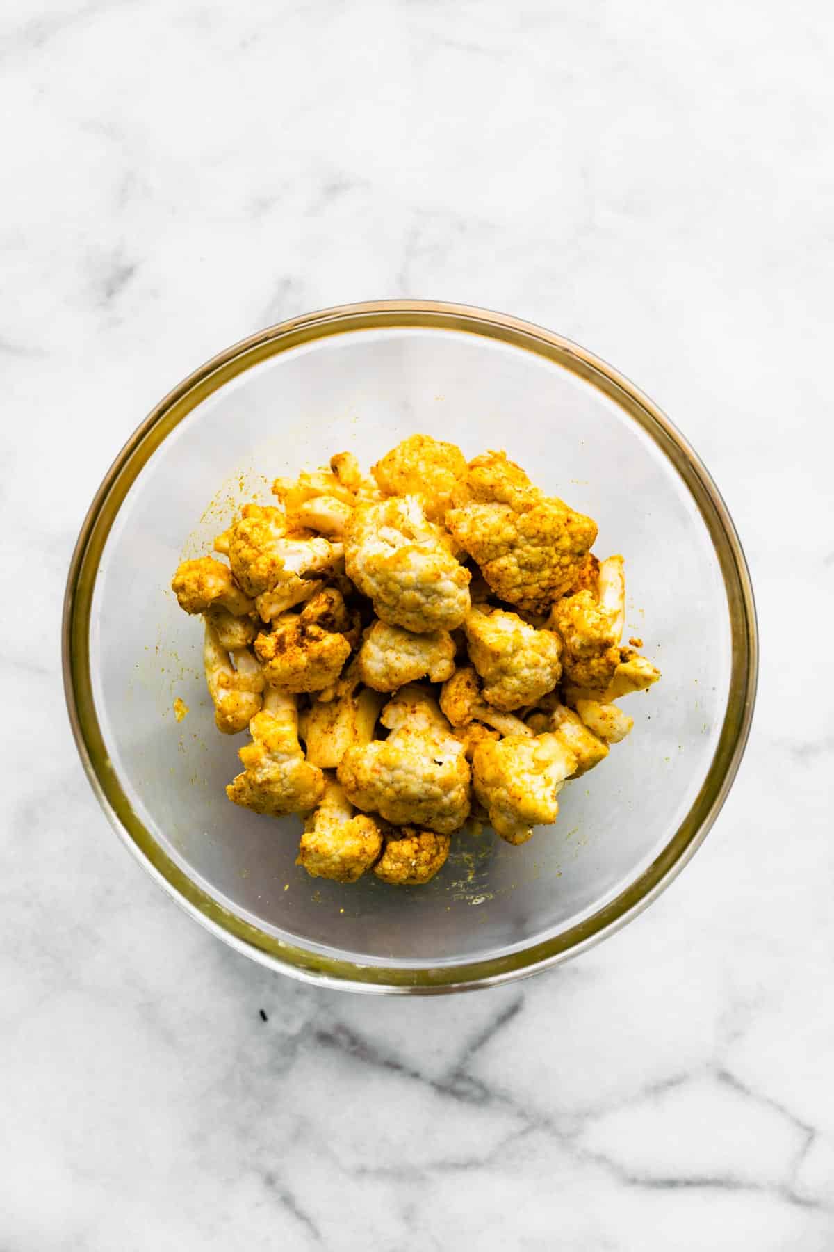 Cauliflower covered in spices in a bowl.