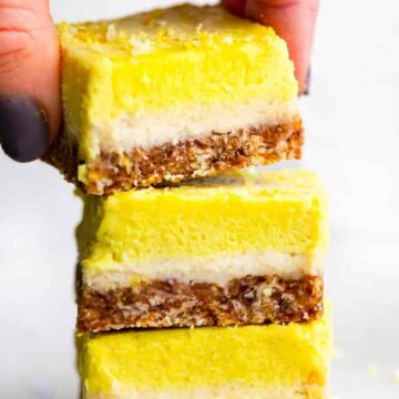 3 No Bake Lemon Cheesecake Bar pieces being stacked on top of one another.