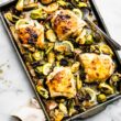 Cooked Honey Mustard Chicken Thighs with Brussels Sprouts on a baking sheet and ready to be served