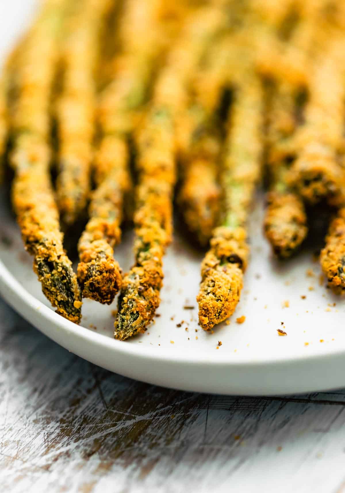 Close up image of air fryer asparagus fries on a plate.