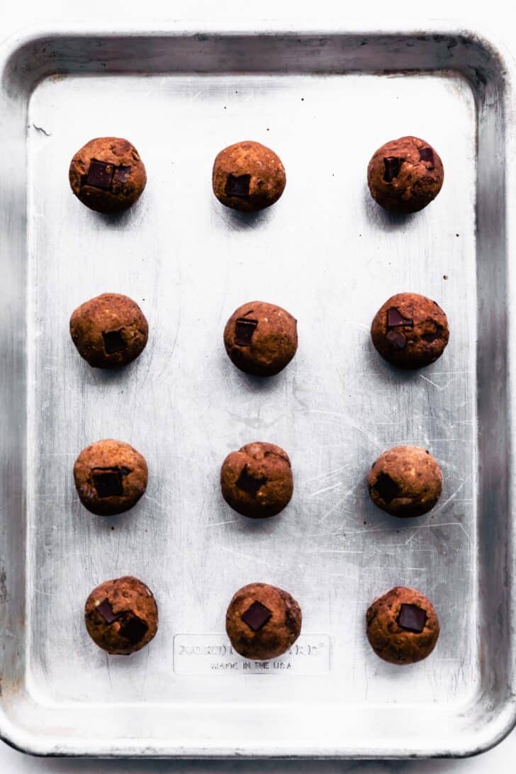 12 frozen chocolate nut-free protein balls on a baking dish.