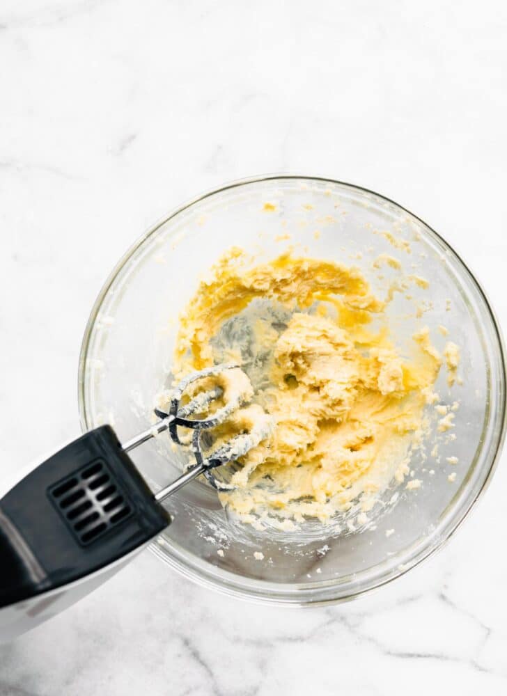 A hand blender in a bowl with gluten free muffin batter.