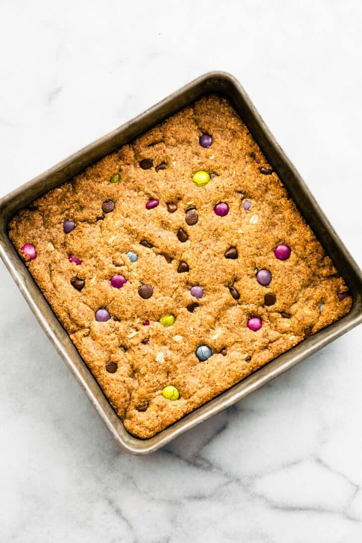 Overhead image of a square baking dish full of unsliced gluten free cookie bars.