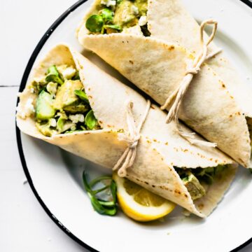 Two gluten-free green goddess chicken salad wraps on a plate.