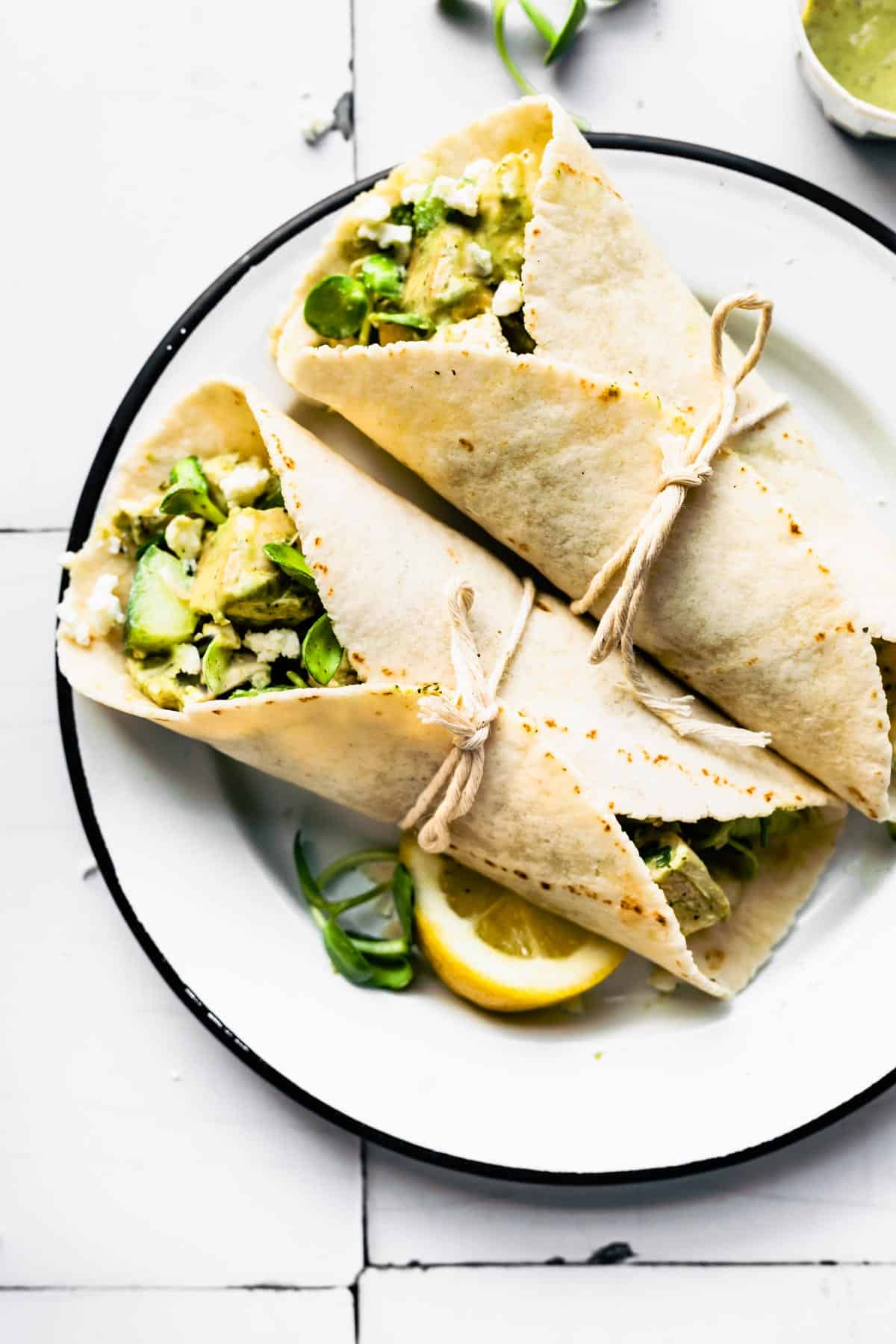 Two gluten-free green goddess chicken salad wraps on a plate.