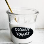 A glass jar labeled "coconut yogurt" full of homemade coconut milk yogurt.
