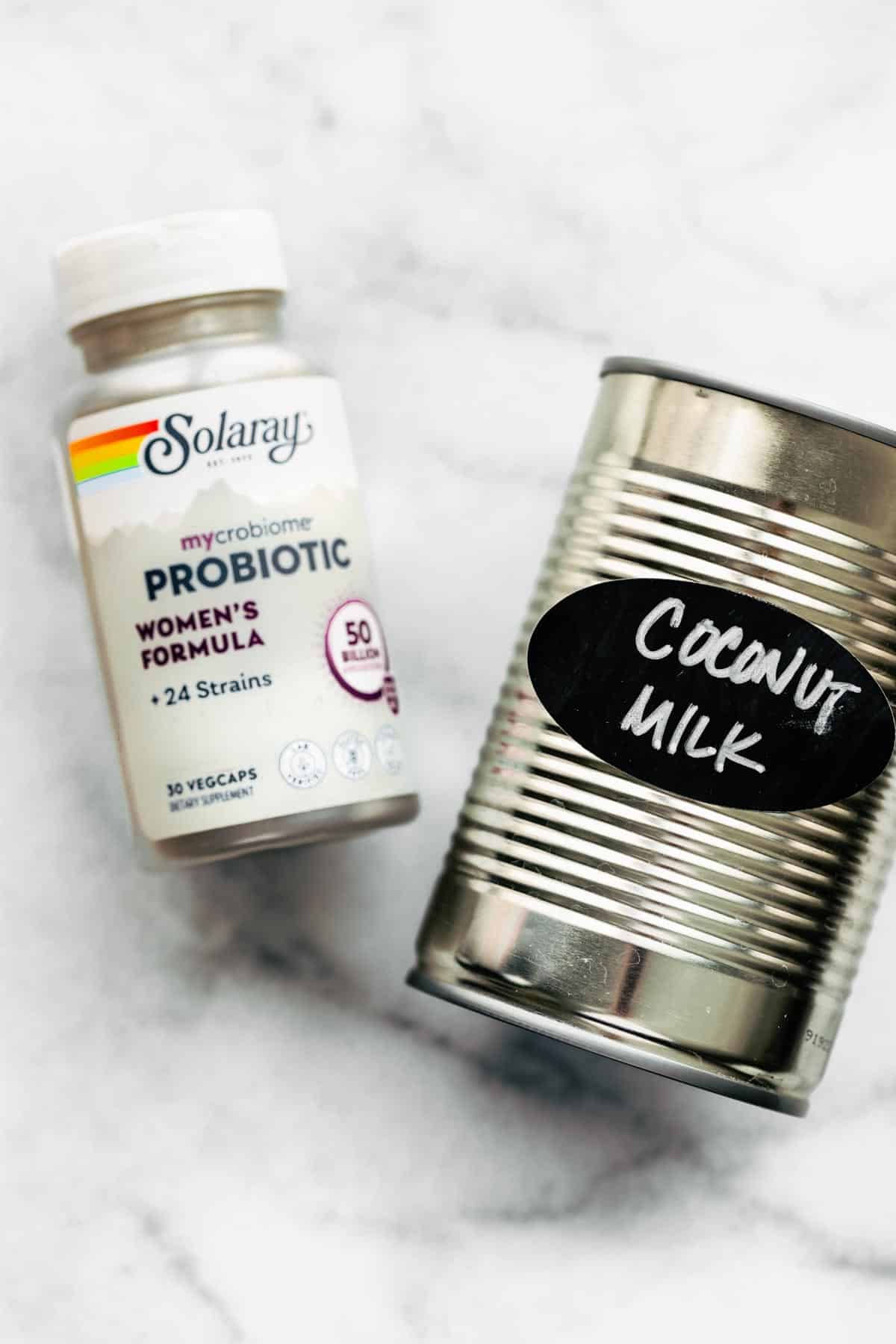 A bottle of mycrobiome women's probiotics and a can of coconut milk.
