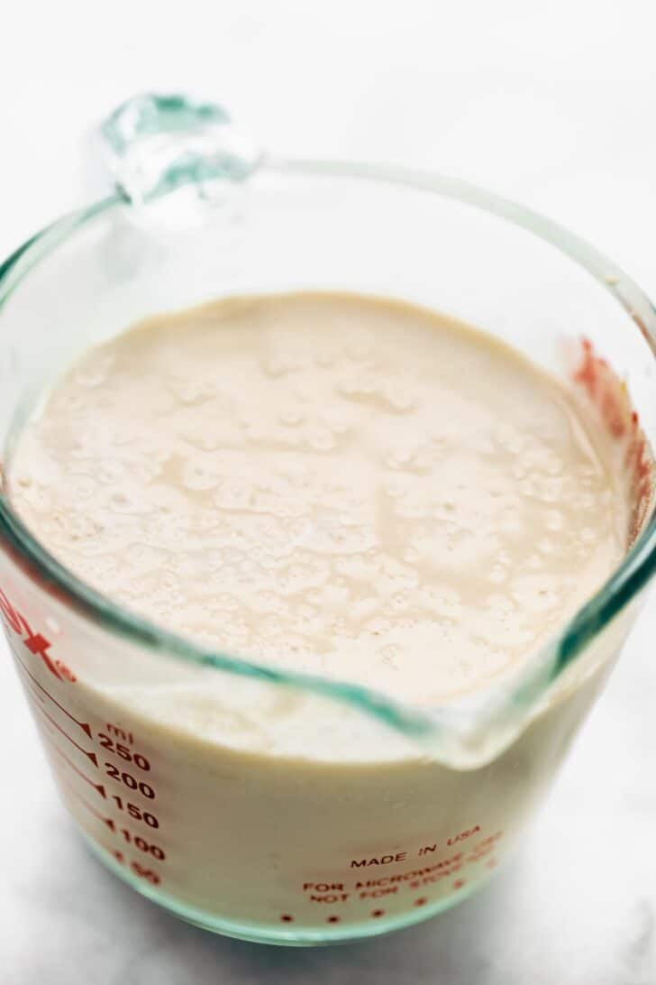 A liquid measuring cup full of vegan buttermilk.
