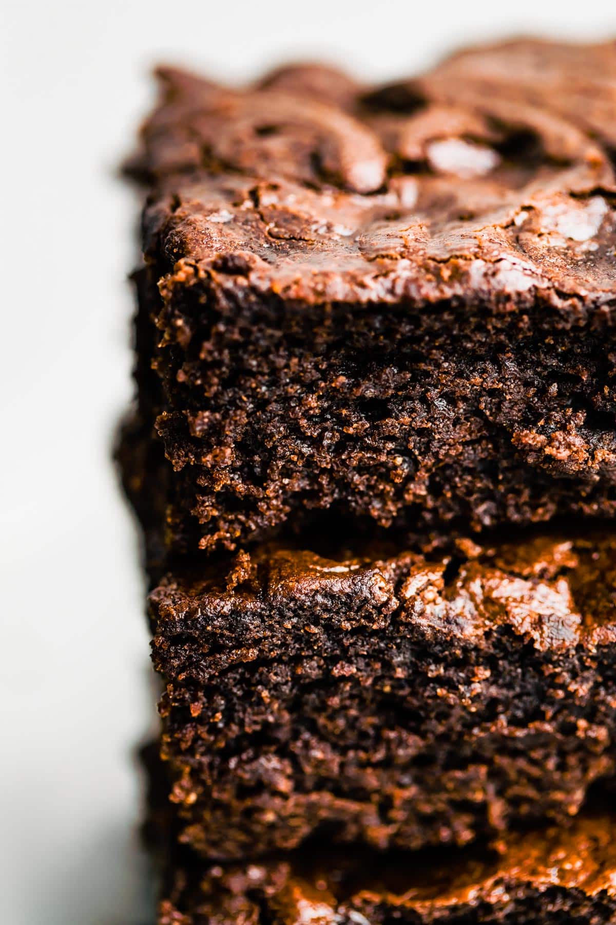 Close up image of gluten free brownies stacked on top of each other showing the fudgy center.