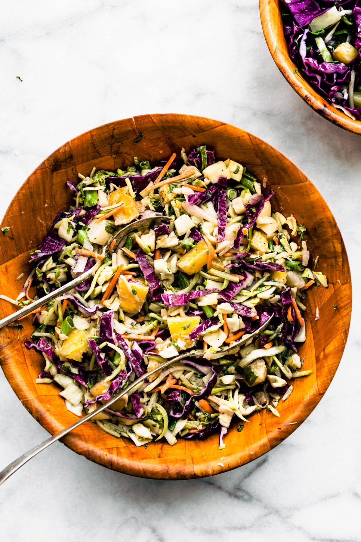 Overhead image of a wooden bowl of easy pineapple coleslaw.