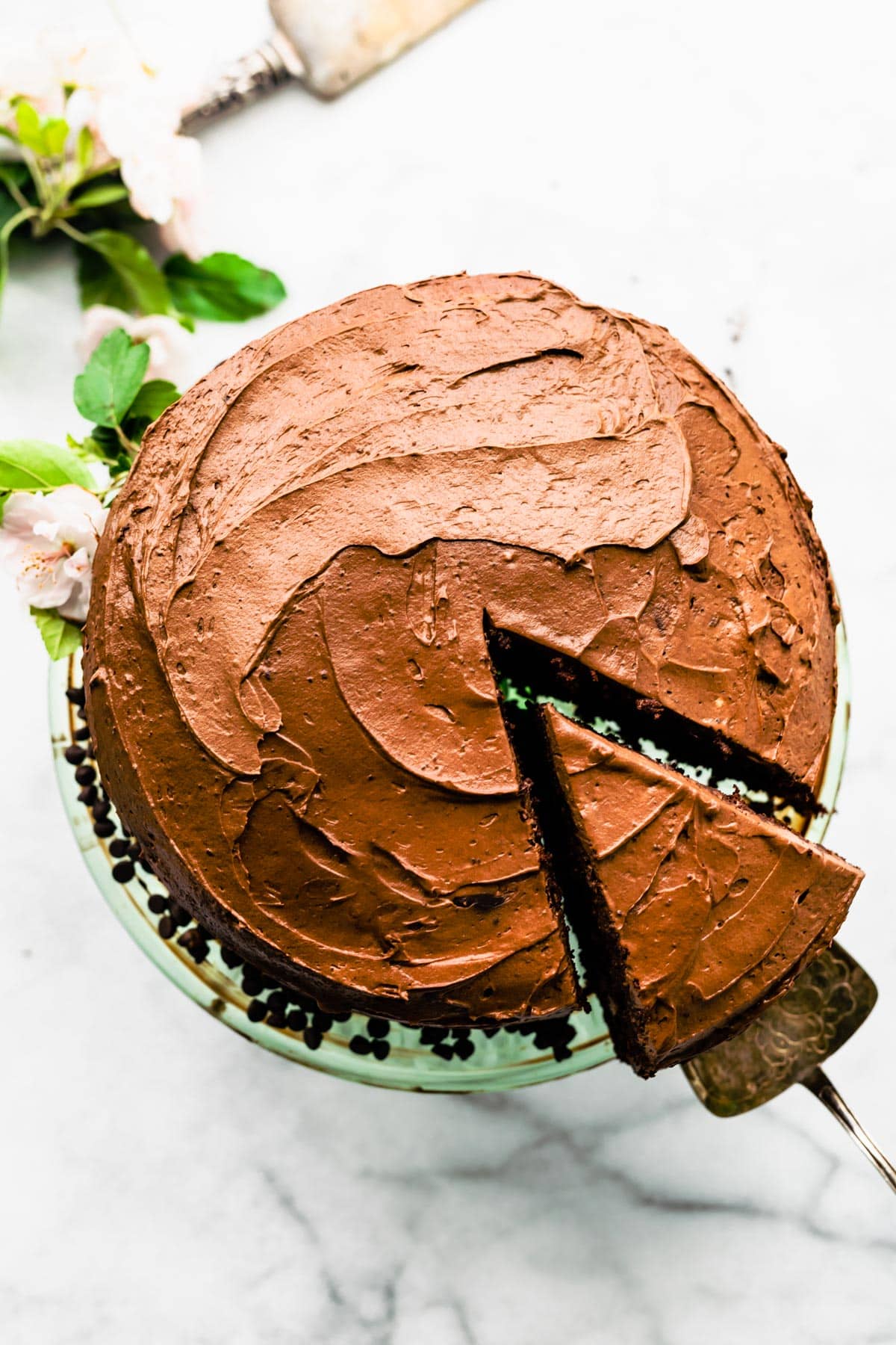 Overhead image of a gluten free chocolate cake with a sliced being lifted.