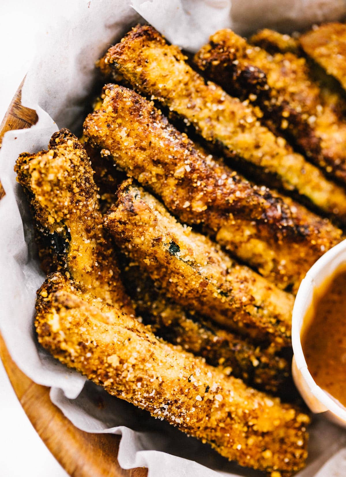 Air fryer fries in a basket lined with parchment paper.