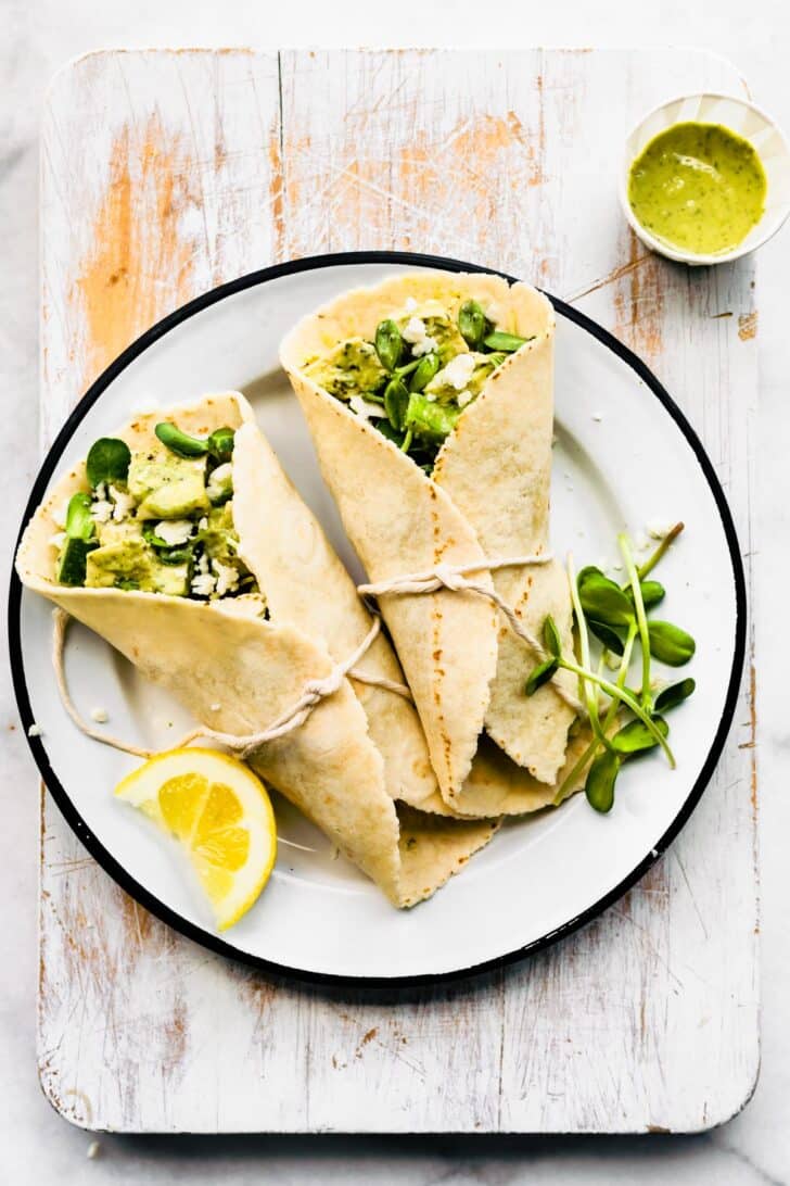 Two gluten free green goddess chicken salad wraps on a plate.