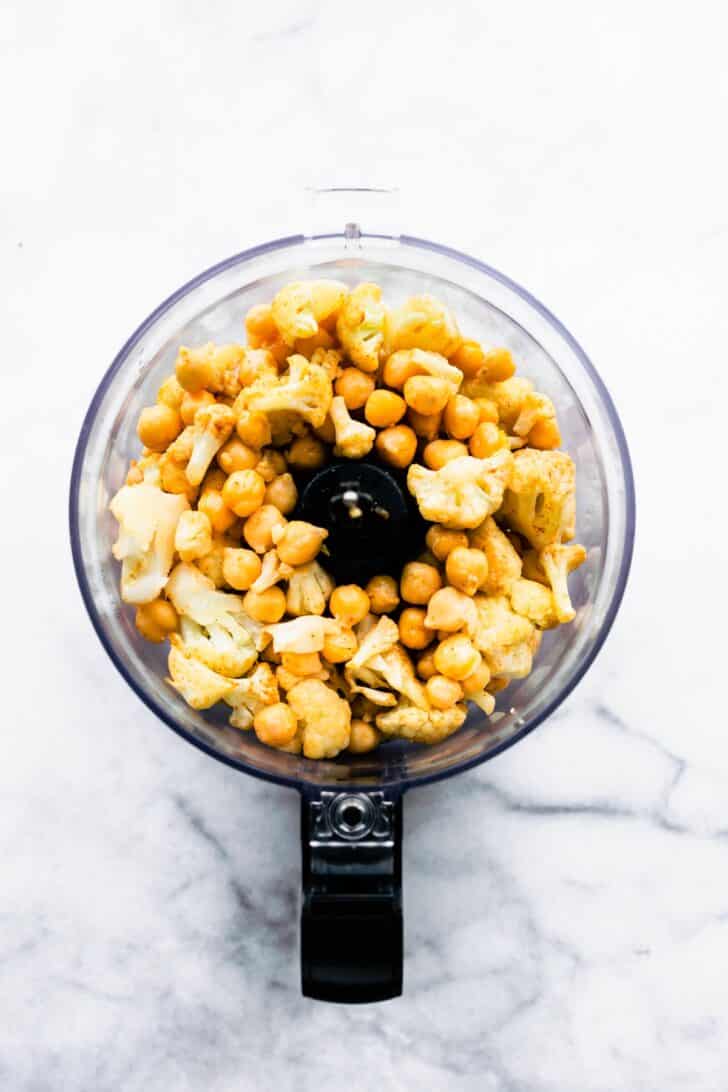 Roasted cauliflower and chickpeas in a food processor for plant based burgers.