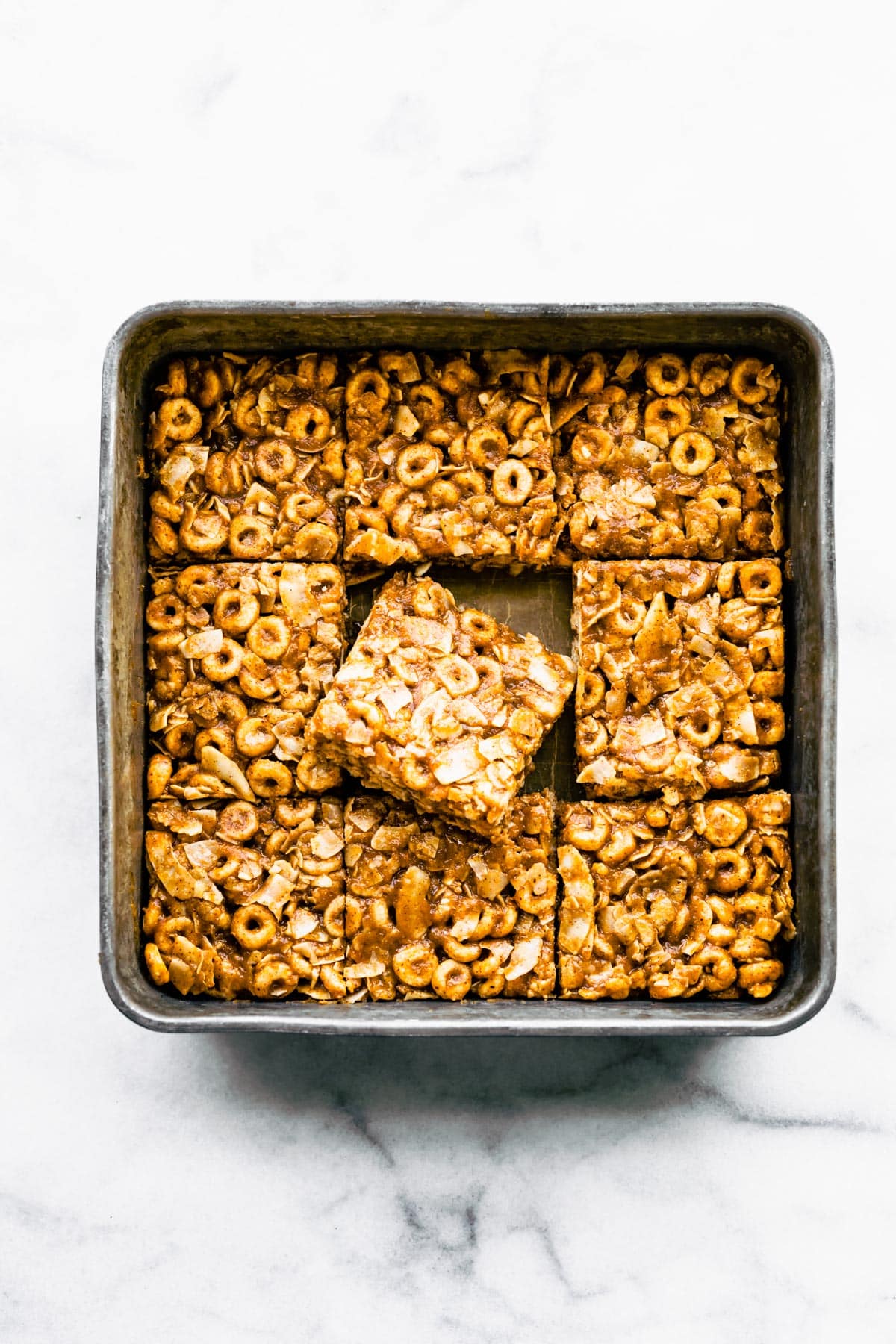 A pan of gluten free cereal bars with the middle piece sitting askew.