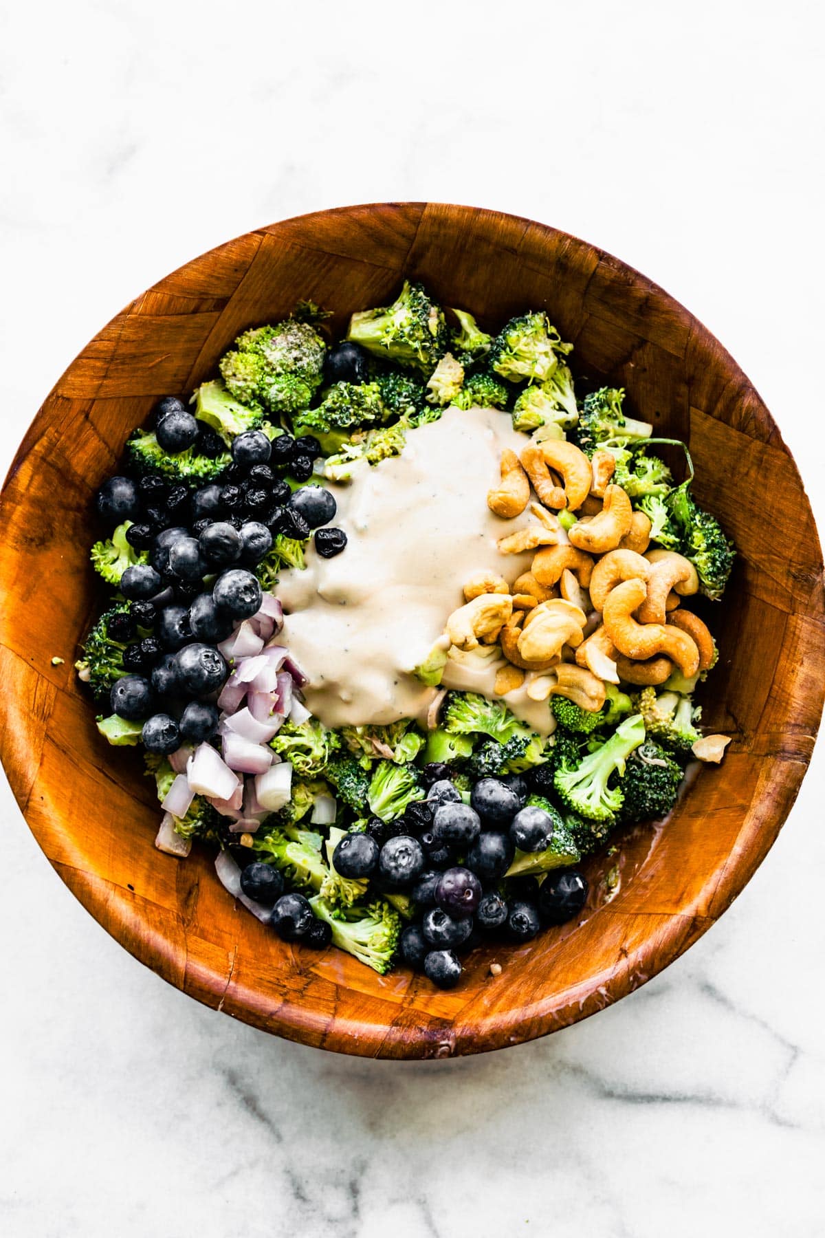 A no mayo yogurt dressing ready to be mixed into a bowl of broccoli salad.