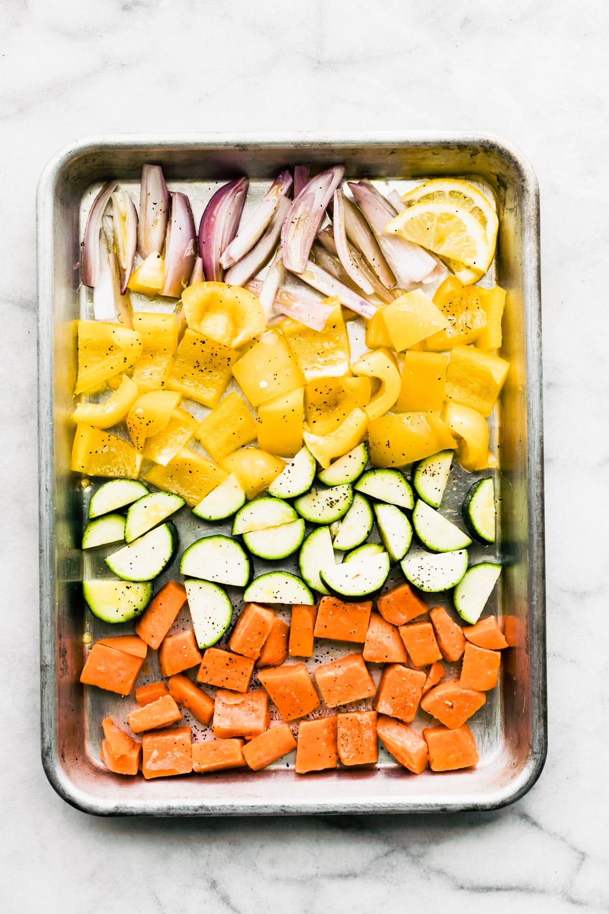 A sheet pan of raw cut up veggies.