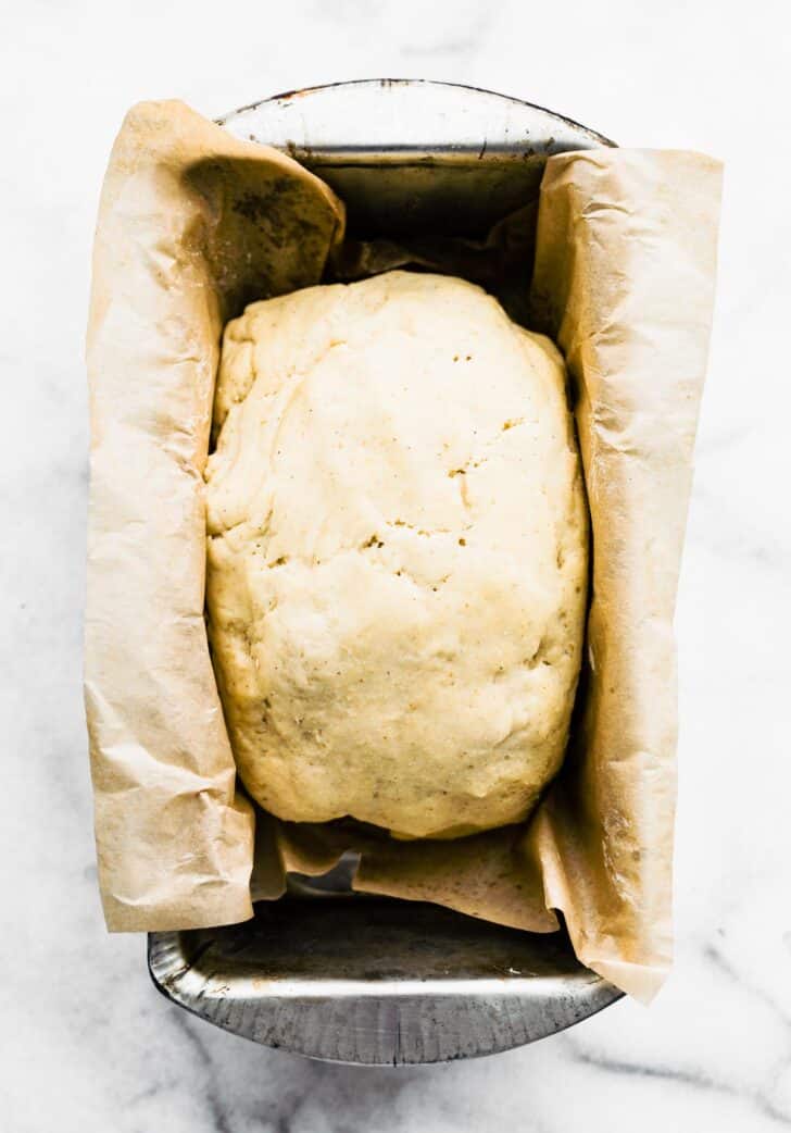 Raw gluten free bread dough in a bread pan.