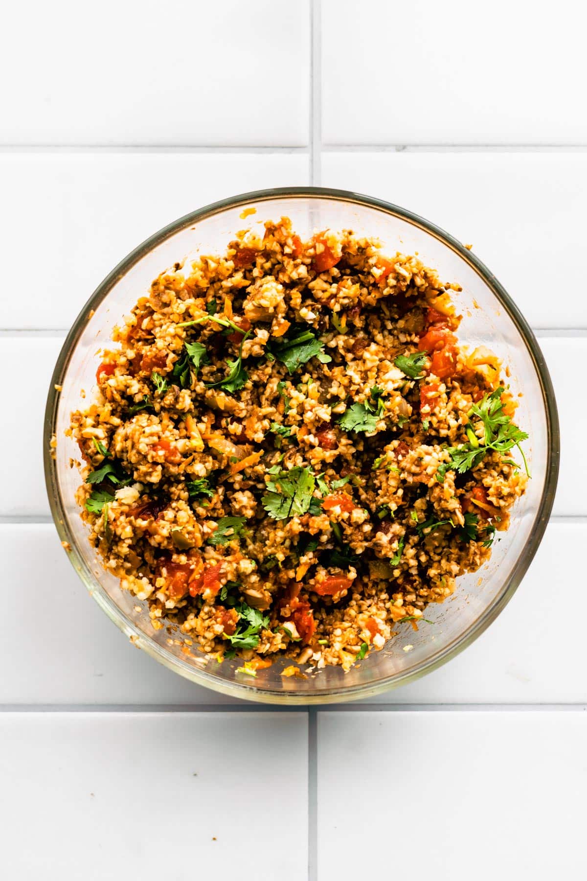 A bowl of vegetarian taco meat, quinoa, diced tomatoes and cilantro.