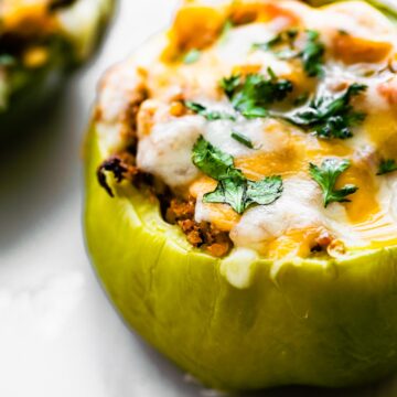 Close up of a bell pepper stuffed with vegetarian taco meat and melted cheese.