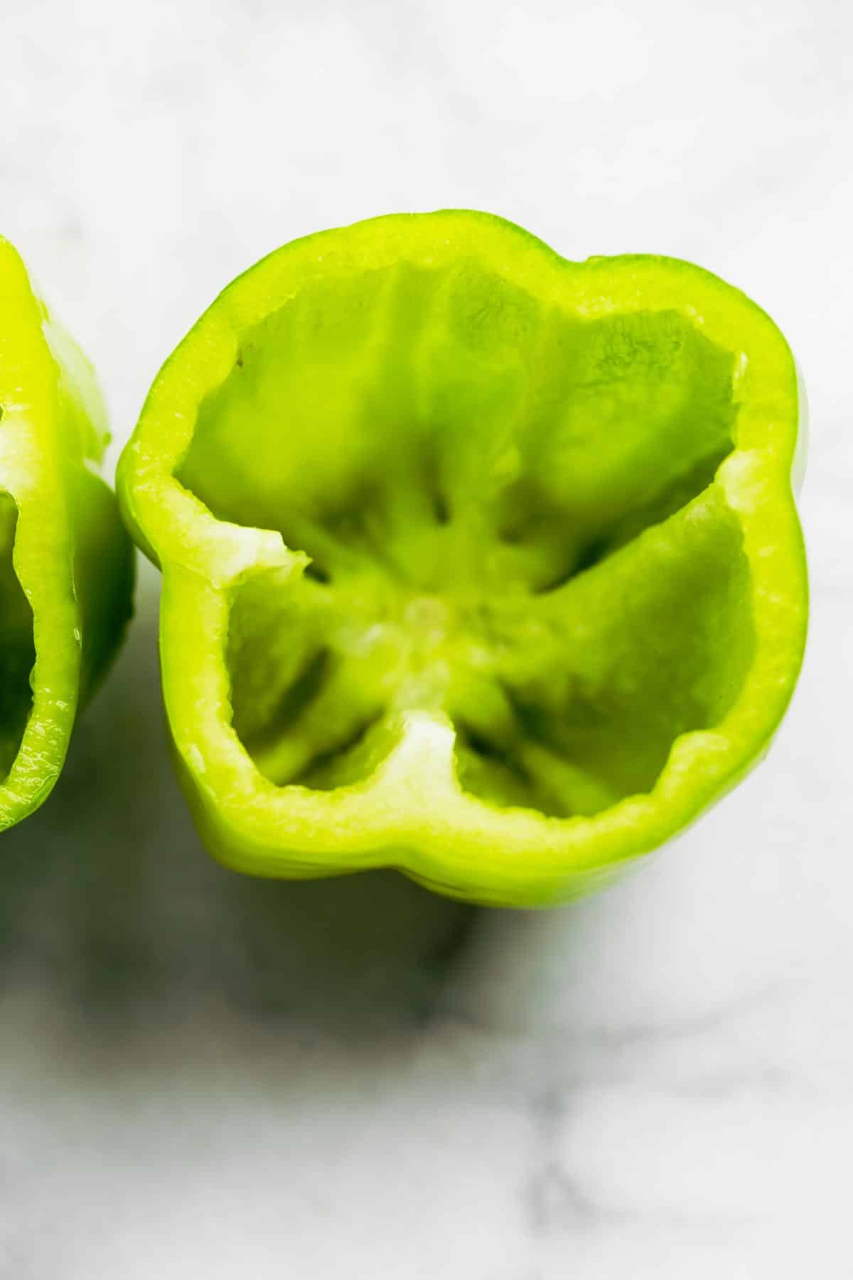 The inside of a green pepper with the top cut off and seeds removed.