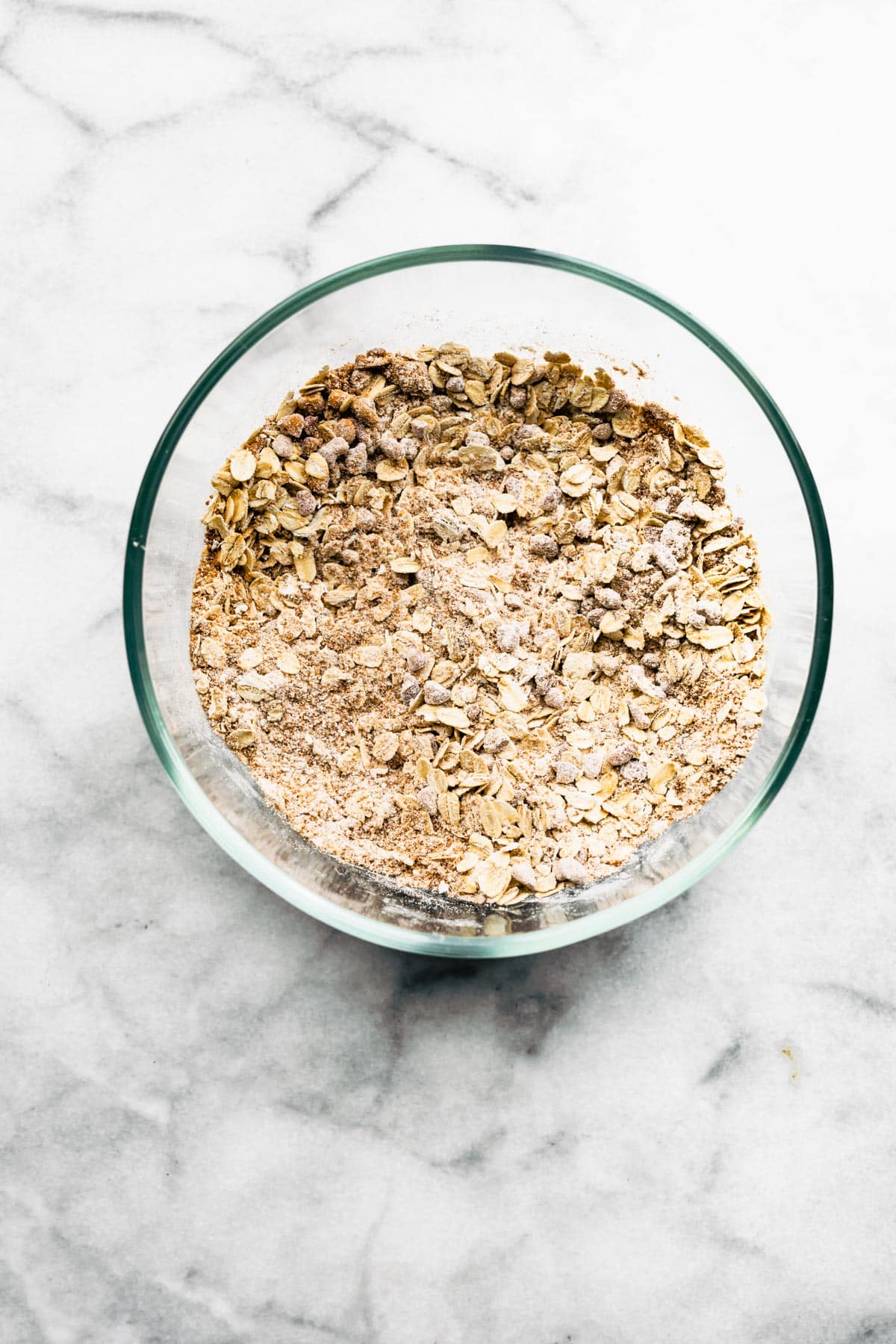 A glass bowl of gluten free oats, flour and spices.