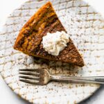 Overhead photo of a slice of gluten free chocolate pumpkin pie topped with whipped cream.